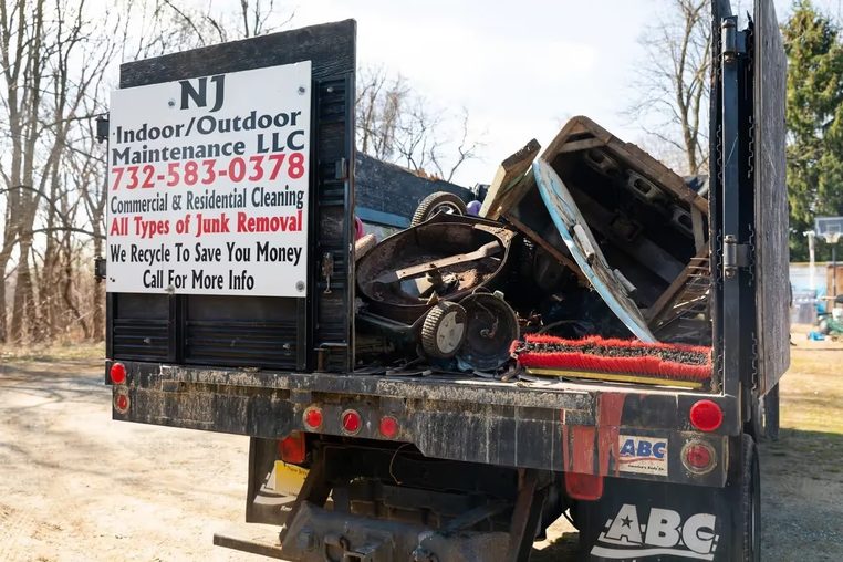 A loaded NJ Indoor Outdoor truck with the company board on the tailgate