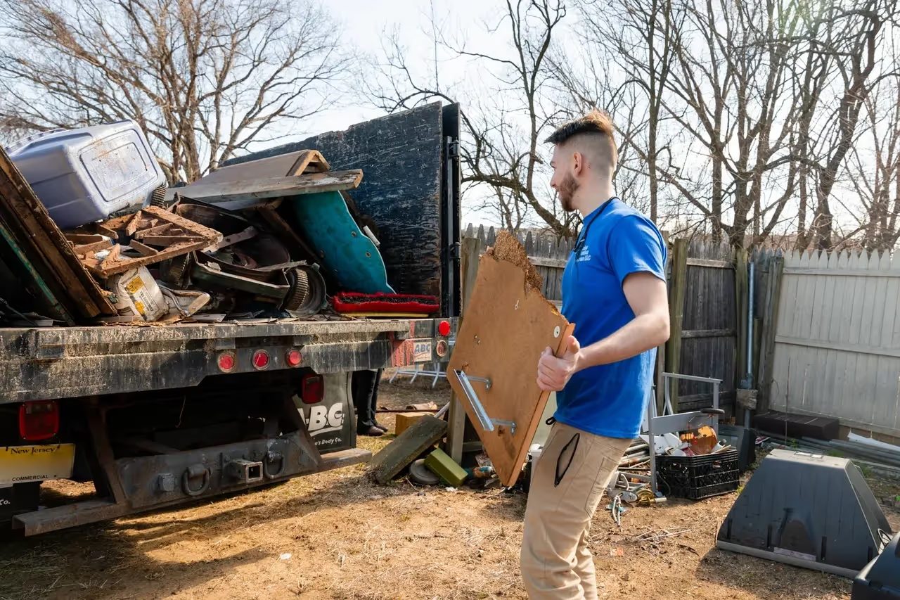 An NJ Indoor Outdoor crew member carrying debris to the truck during a residential cleanout