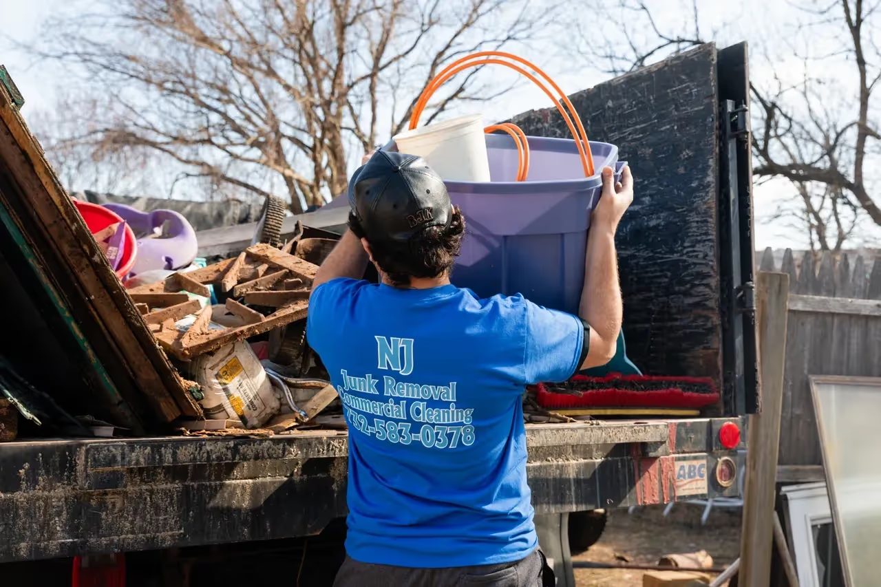 A crew member sorting household items into the truck for donation and recycling