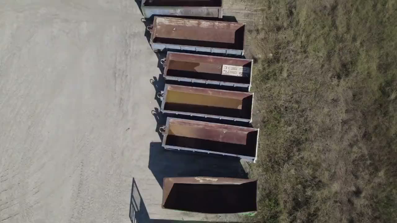Roll-off dumpsters lined up ready for delivery, seen from above
